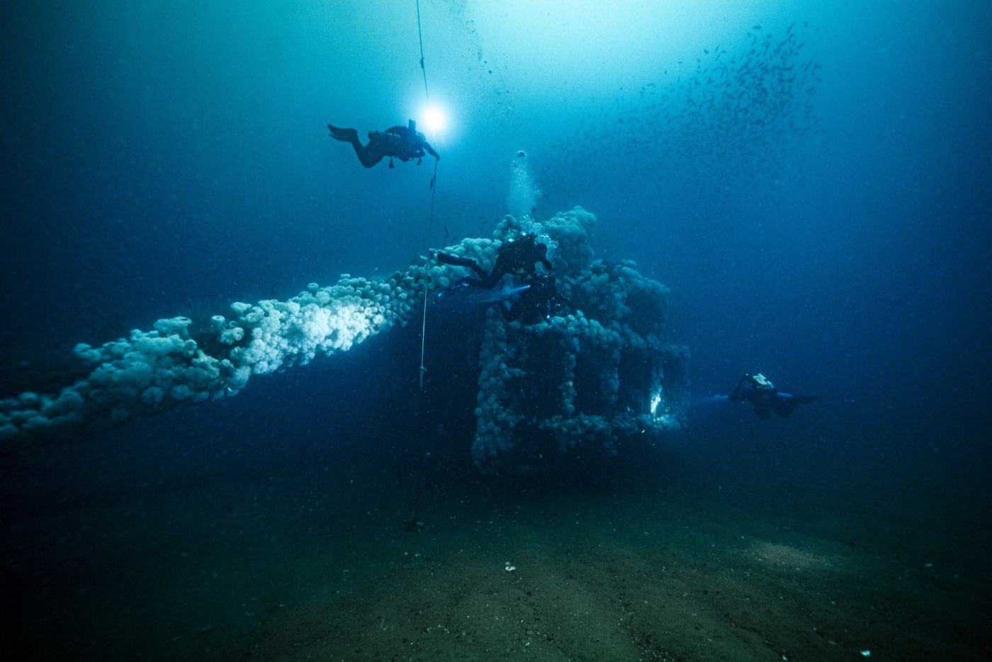 Two technical divers approach the Missile Tower down the line